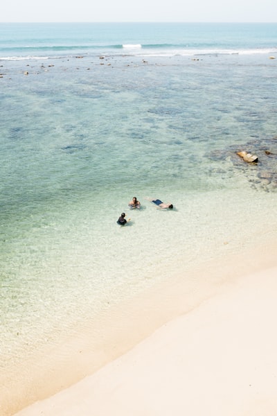 人们在海边的海滩游泳